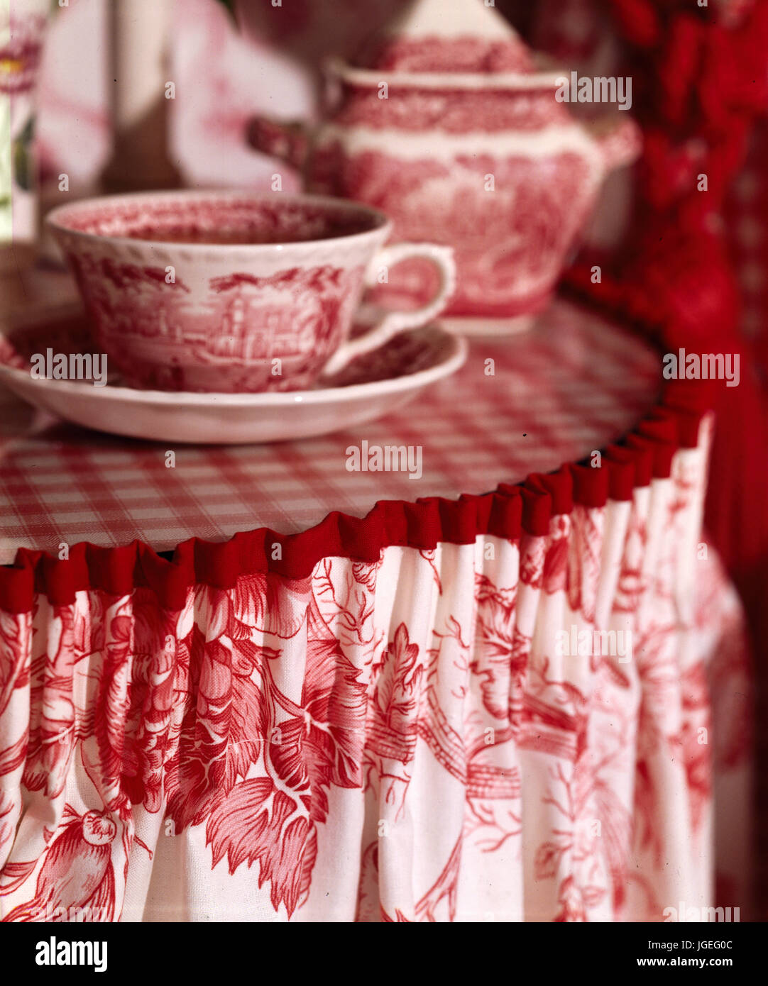 Nahaufnahme der Beistelltisch mit roten und weißen bedruckten Stoff Rock und Teetasse Stockfoto