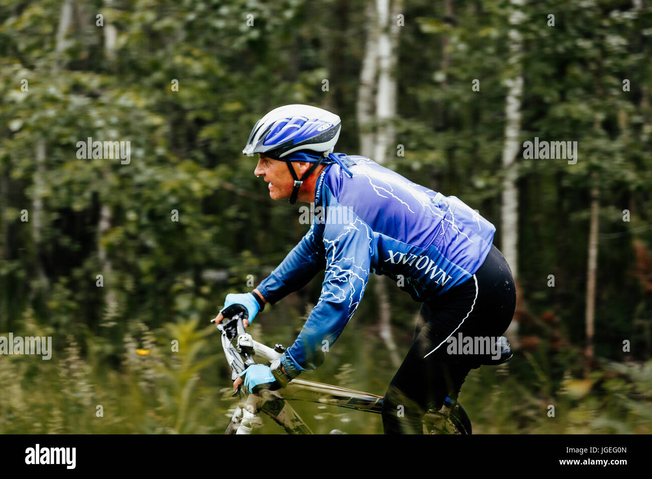 Close-up Mann mittleren Alters Radsportler im Wald bei regionalen Wettkämpfen auf Mountainbike Stockfoto