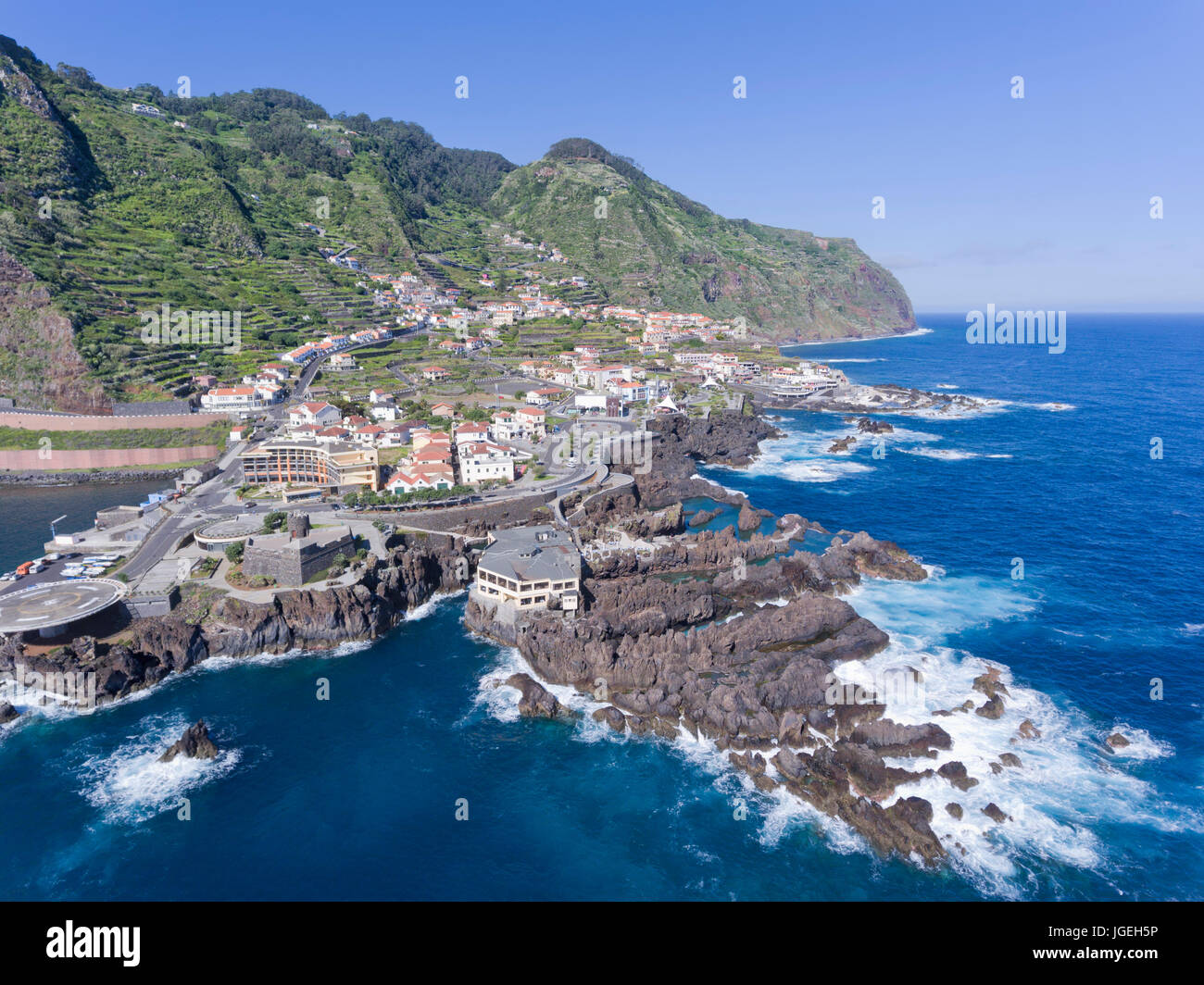 Luftaufnahmen von Madeira Insel kleine Stadt von Porto Moniz mit natürlichen Schwimmbecken unter vulkanischen Gesteinen, Häuser auf terrassierten Berghängen. Stockfoto