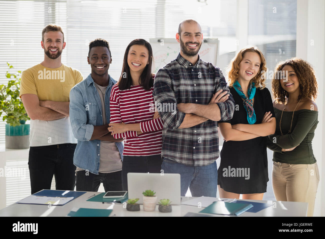 Porträt des Teams von Führungskräften stehen zusammen mit verschränkten im Büro Stockfoto