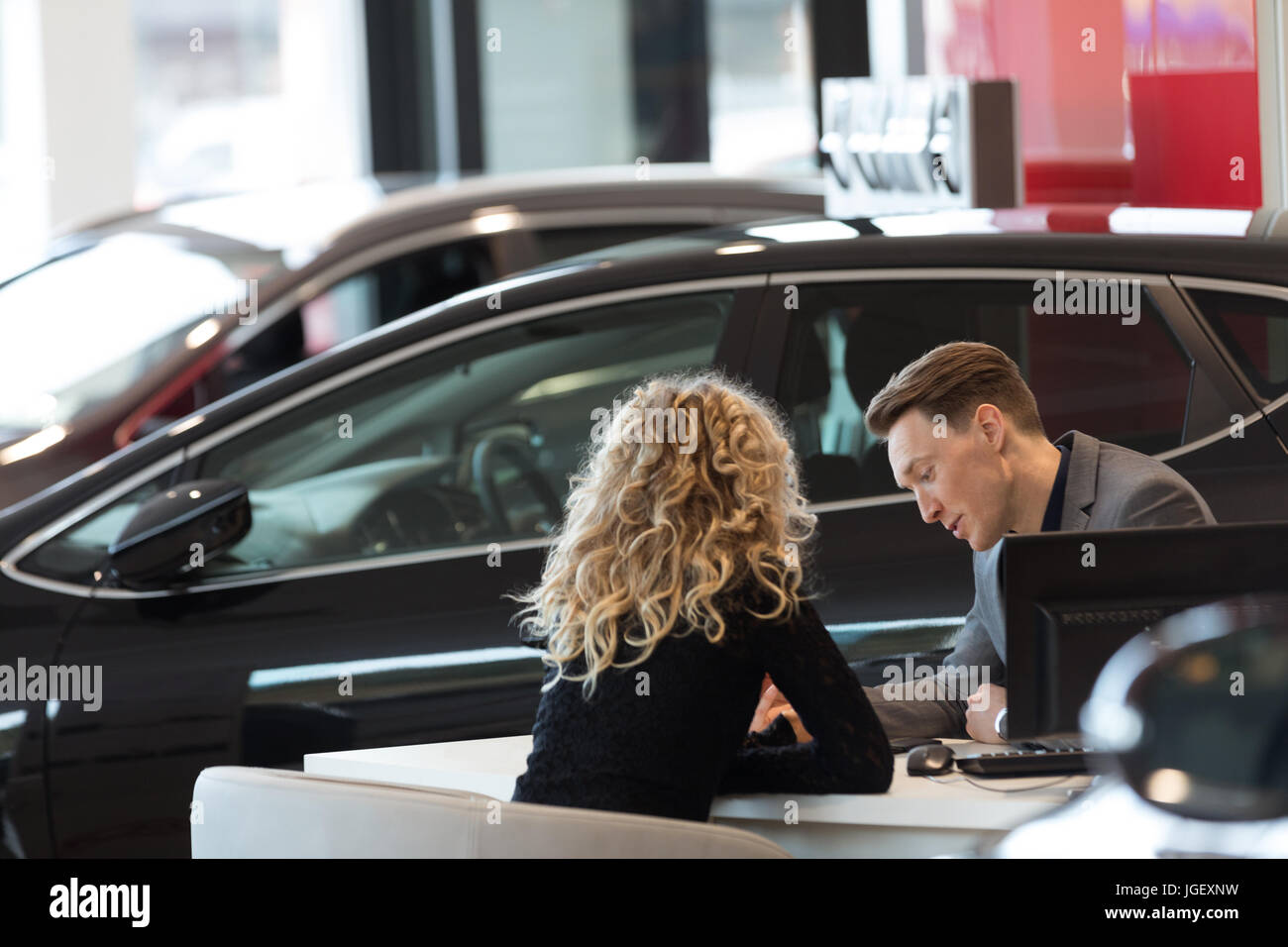 Auto Verkäufer Diskussion mit Kunden im Schauraum Stockfoto