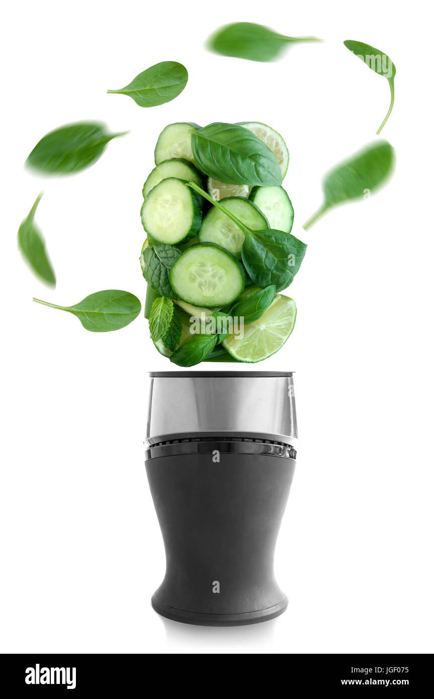 Frische grüne Früchte und Gemüse über einen Mixer auf weißem Hintergrund Stockfoto