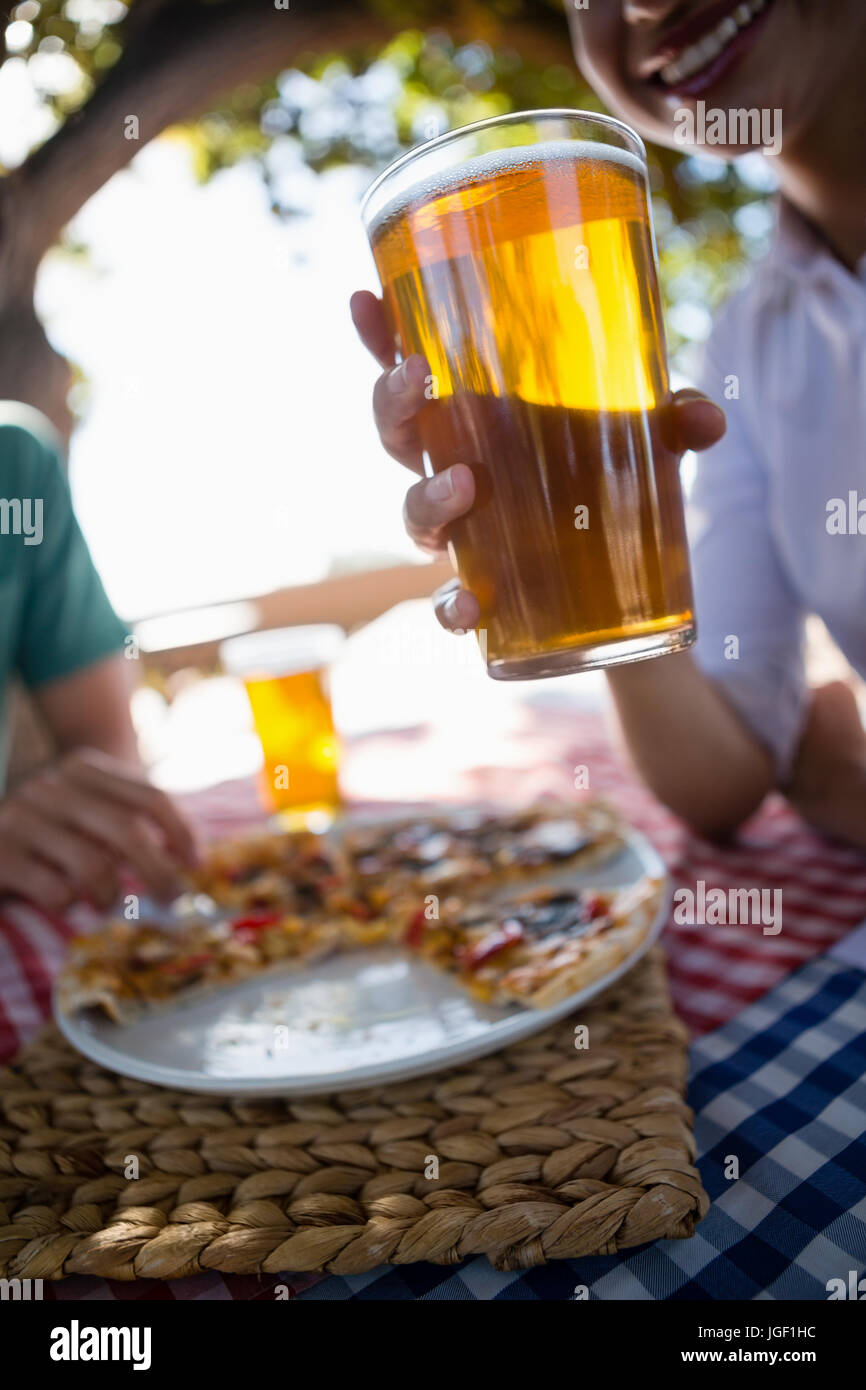 Zugeschnittenes Bild Frau mit Bierglas am Tisch im Restaurant im freien Stockfoto