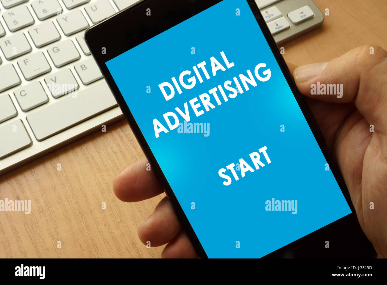 Hände halten Telefon mit Seite digitale Werbung. Stockfoto