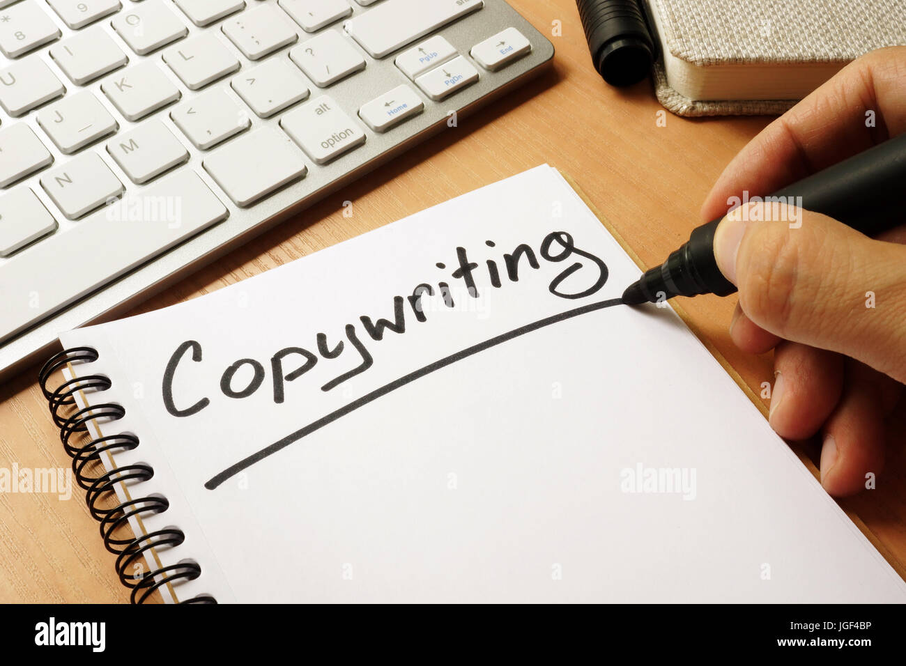 Hand ist das Copywriting auf eine Notiz schreiben. Stockfoto