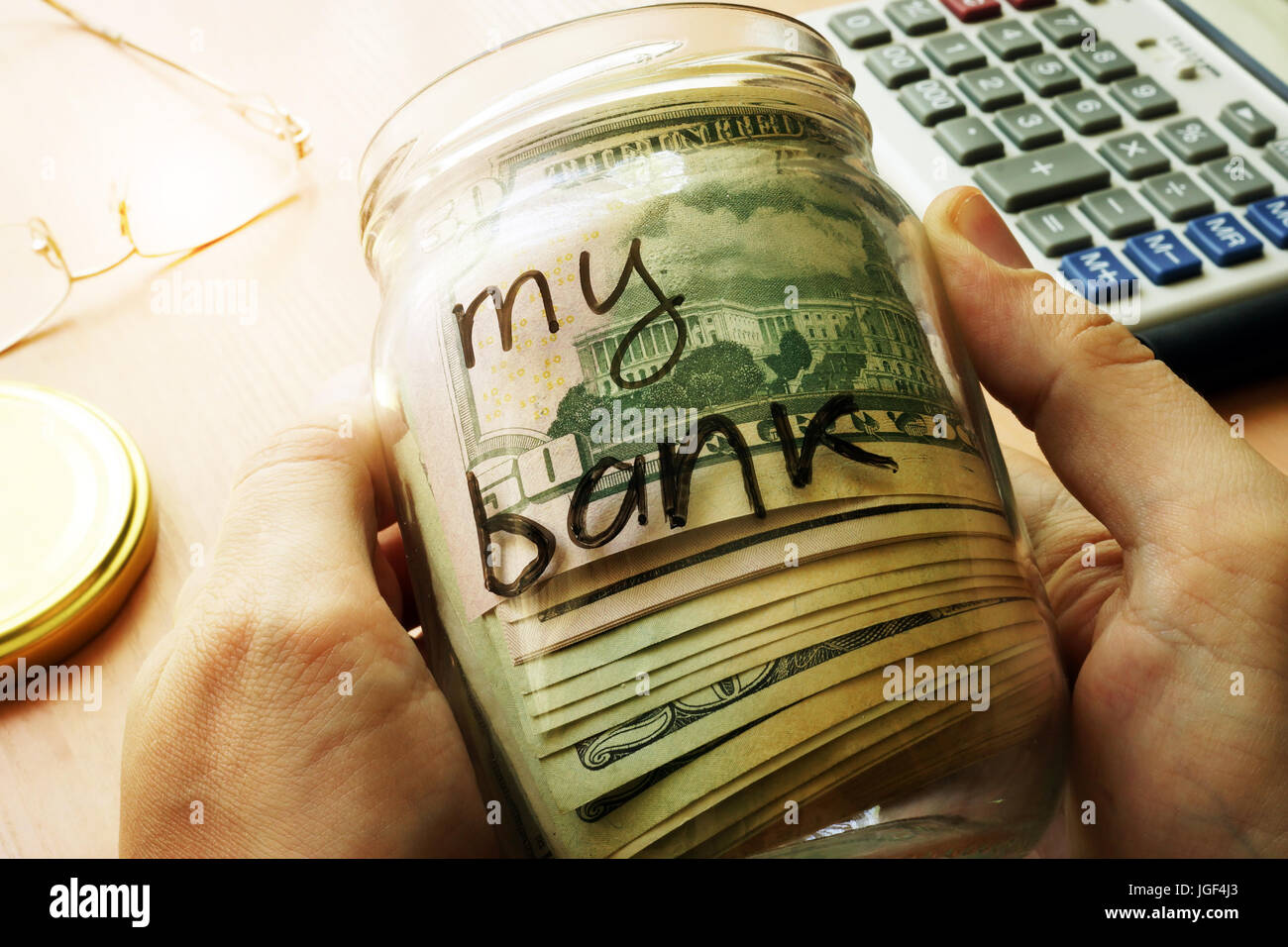 Glas mit Dollar und meine Bank auf einer Seite zu unterzeichnen. Persönliche Finanzen und Einsparungen-Konzept. Stockfoto
