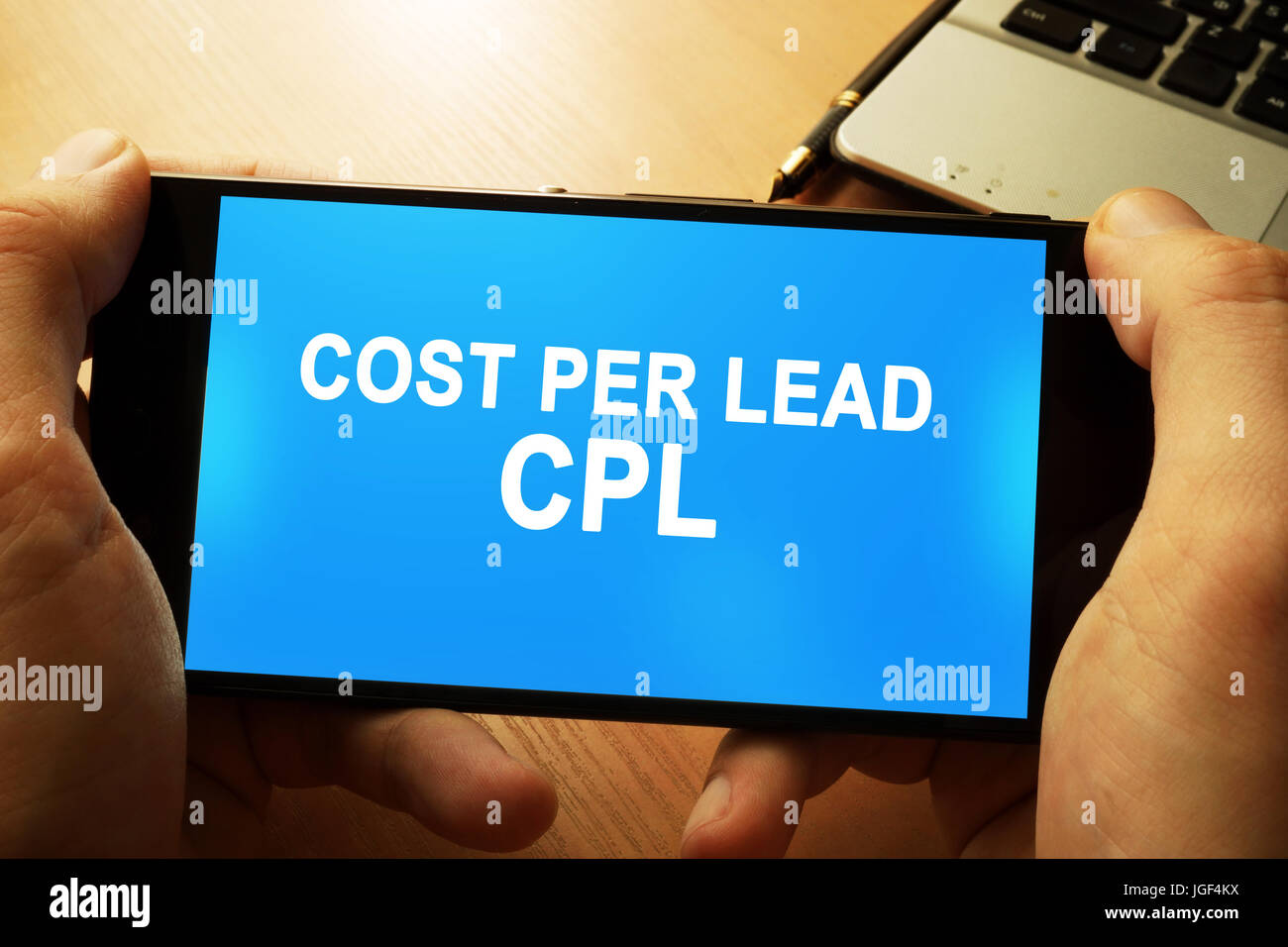 Hand mit Smartphone mit Worten Kosten pro Lead kpl. Stockfoto