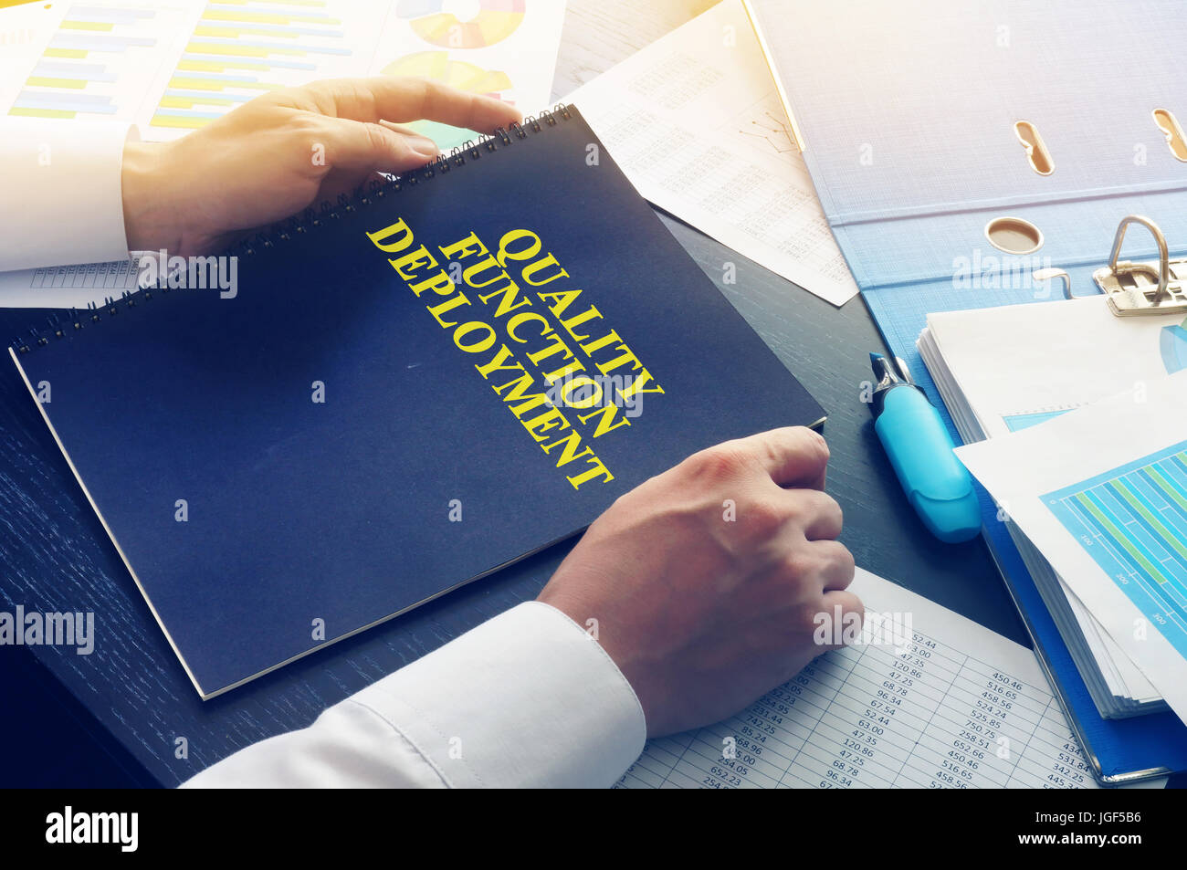 Manager nimmt Buch QFD - Qualität Funktion Deployment. Stockfoto