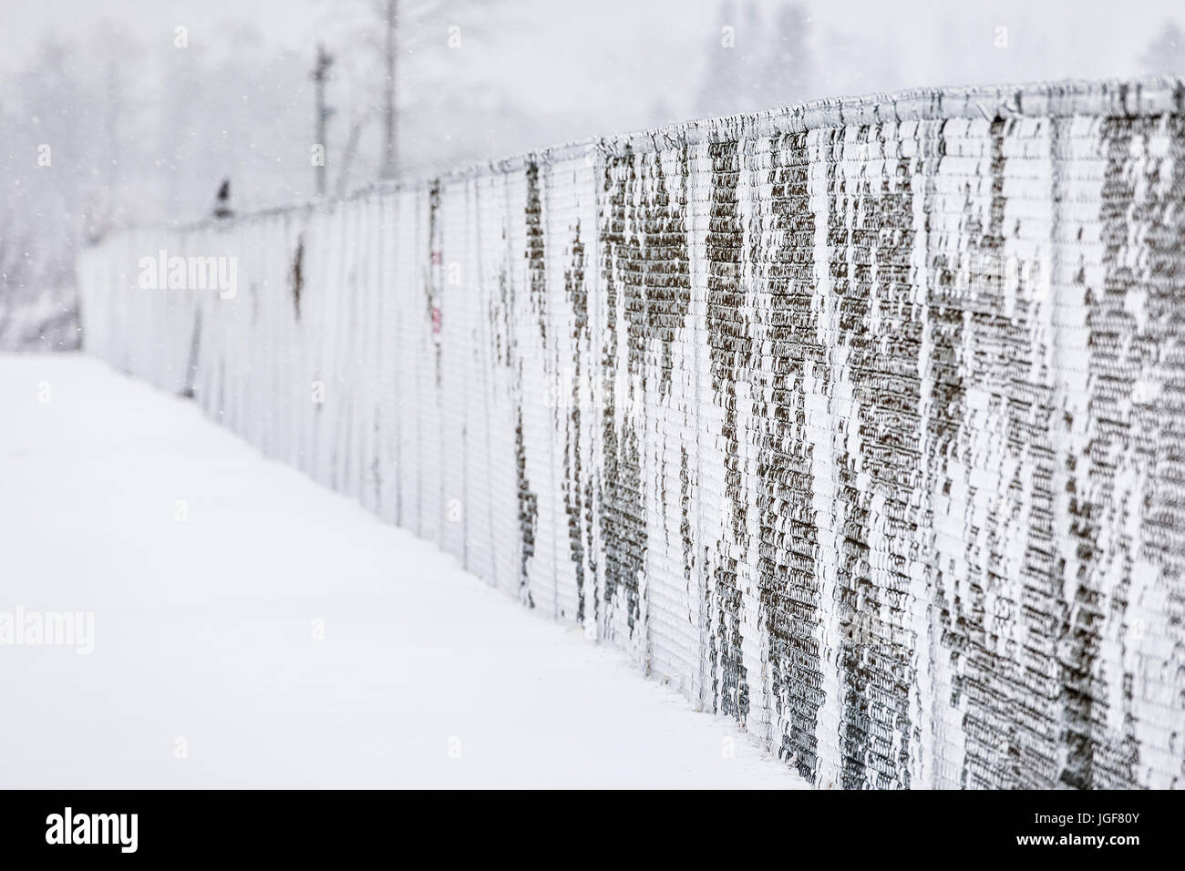 Maschendrahtzaun bedeckt mit Eis und Schnee, Thunder Bay, Ontario, Kanada. Stockfoto