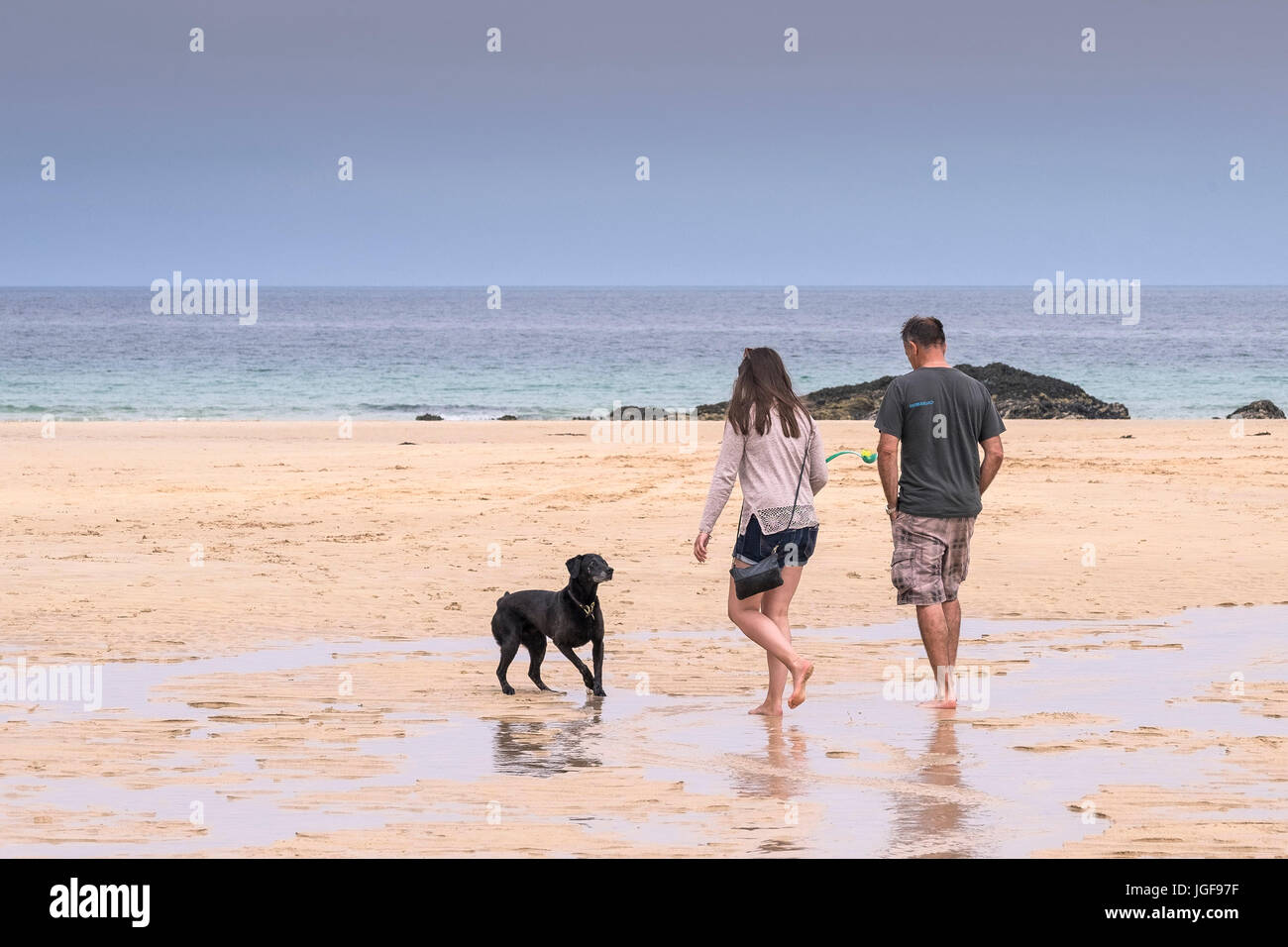 Menschen am Strand.  Urlauber und ihrem Hund am Strand entlang Harlyn Bay in Cornwall. Stockfoto