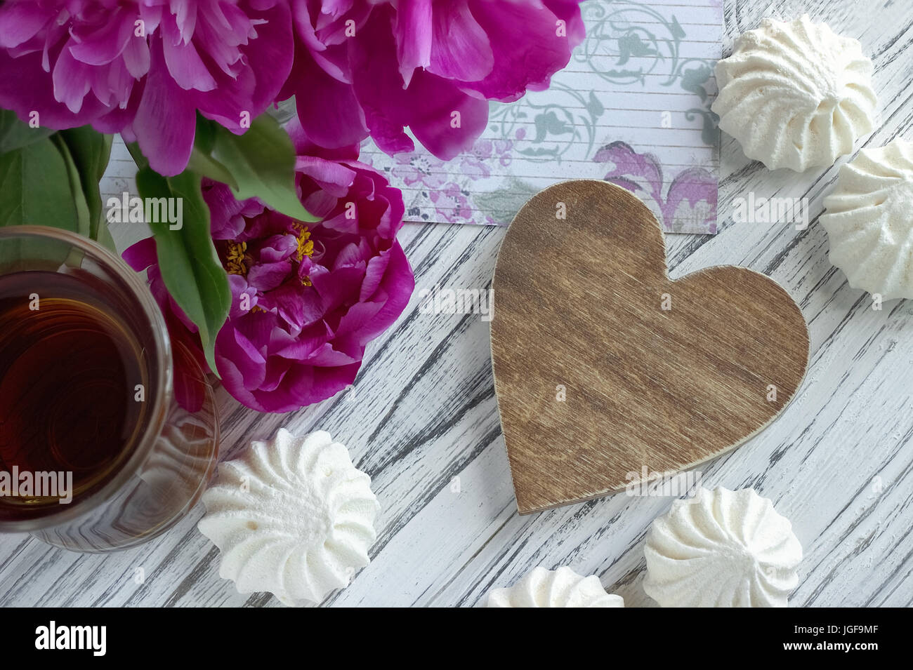 Päonien Blüten rosa Glas Tee mit braunem Holz- Herzen Marshmallow auf weißem Hintergrund Holz-stock Bild Stockfoto