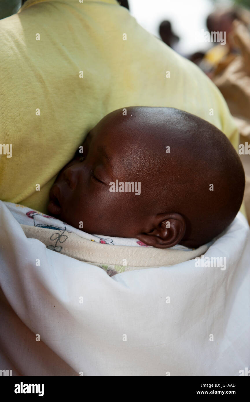 Baby schläft im Tragetuch auf dem Rücken der Mütter, Ruanda. Stockfoto