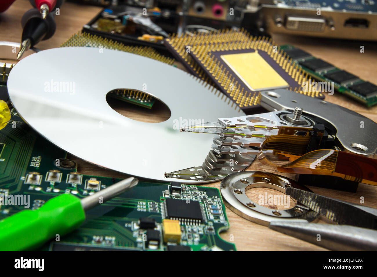 Platte, Stellarm und Vorstand von zerlegten HDD mit Werkzeugen in PC-service Stockfoto