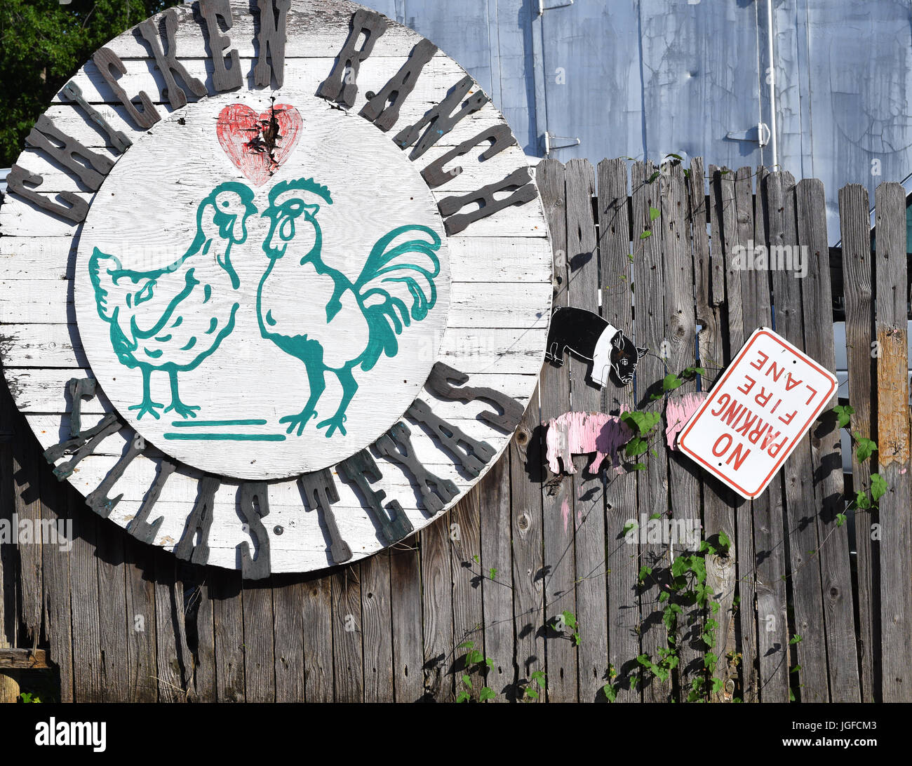 Ungerade Huhn Schild an einem Holzzaun Stockfoto