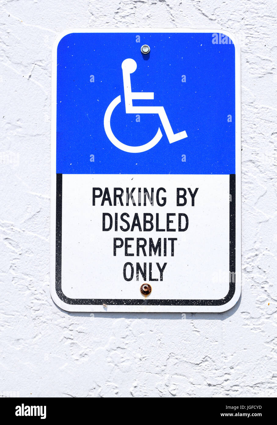 Behindertenparkplatz Zeichen auf Seite des Gebäudes Stockfoto