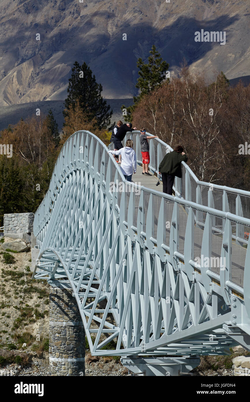 Touristen auf Fußgängerbrücke über Lake Tekapo Steckdose zur Kirche des guten Hirten, Mackenzie Country, Canterbury, Südinsel, Neuseeland Stockfoto