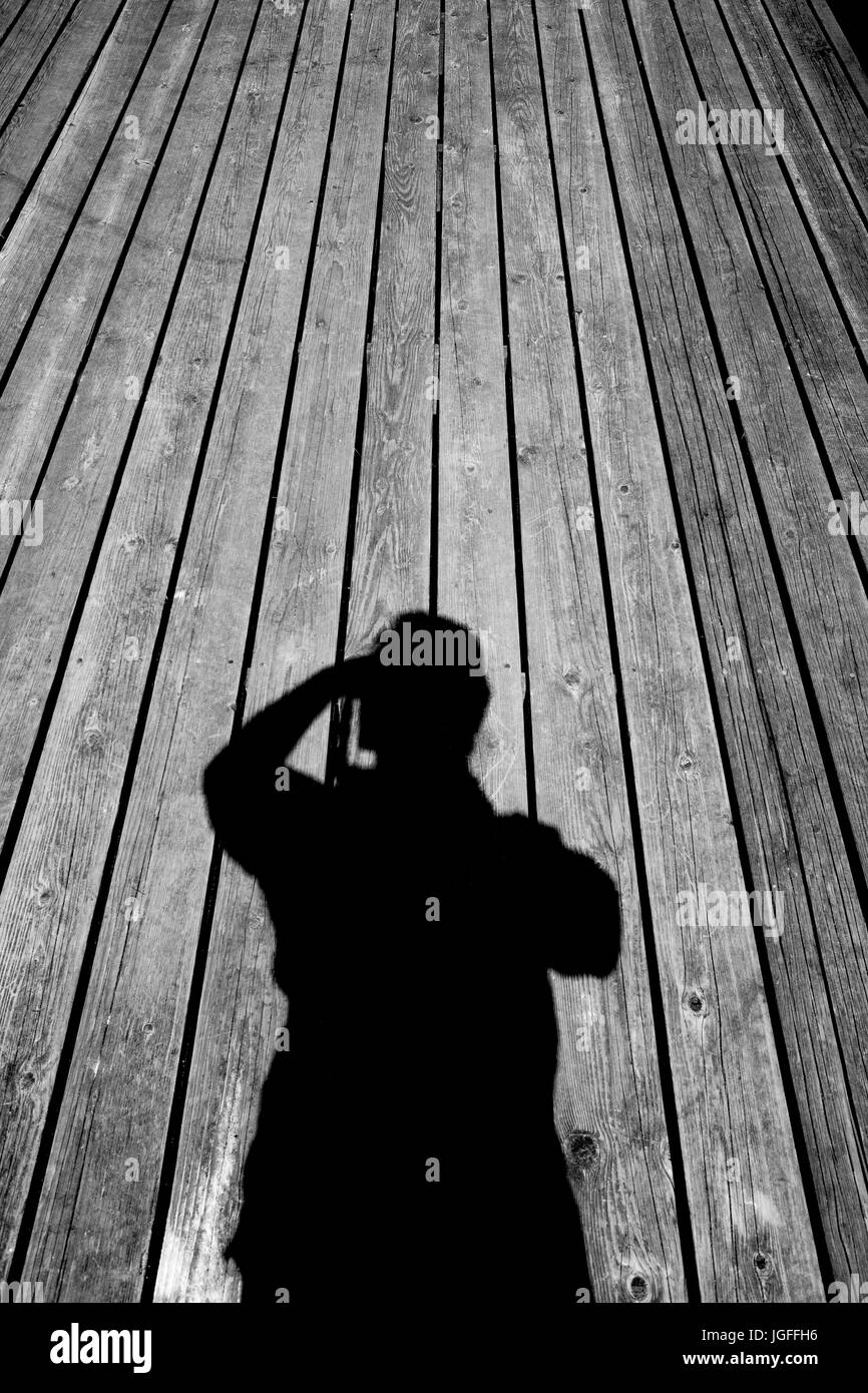 Schatten des kaukasischen Mann mit Kamera auf Holzboden Stockfoto
