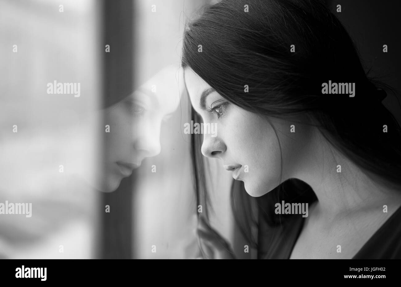 Kaukasische Frau schiefen Stirn am Fenster Stockfoto