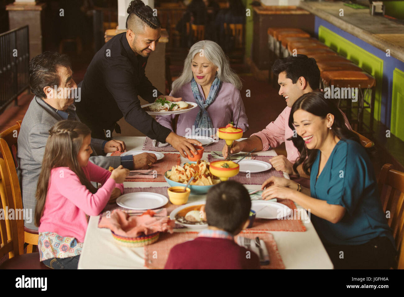 Kellner, Essen, Familie im Restaurant serviert Stockfoto