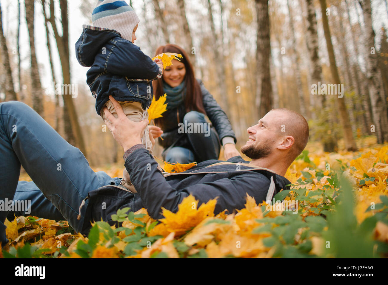 Nahen Ostens Verlegung im Herbstlaub hält Baby Sohn Vater Stockfoto