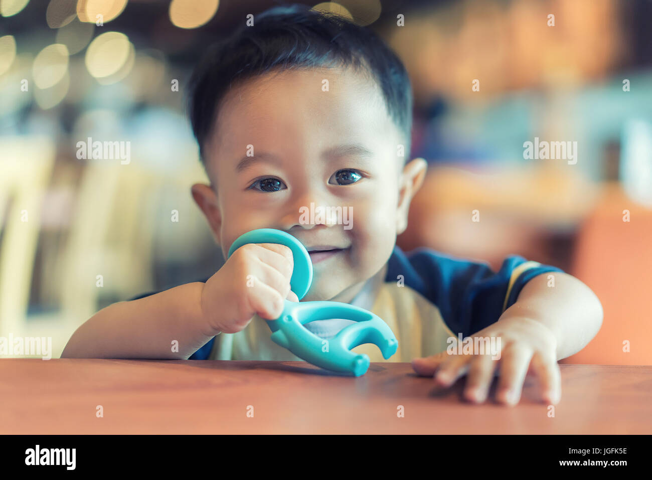 9 Monate altes lindert asiatisches Baby junge saugen seinen Kautschuk-Biss-Spielzeug für Zahnschmerzen. Stockfoto