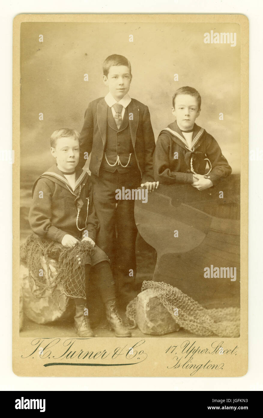 Originales Sepia-farbiges Cabinet Card Studio-Porträt mit Hintergrund am Meer von 3 jungen viktorianischen Jungen, die in Matrosenanzügen posierten, datiert 1888, Islington, London, Großbritannien Stockfoto