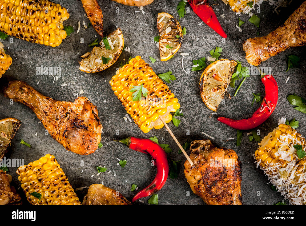Sommer essen. Ideen für Grill, Grill-Party. Mais und Hühnchen (Beine, Flügel) gegrillt, gebraten in Brand. Mit einer Prise Käse (Elotes) hot Chili pep Stockfoto