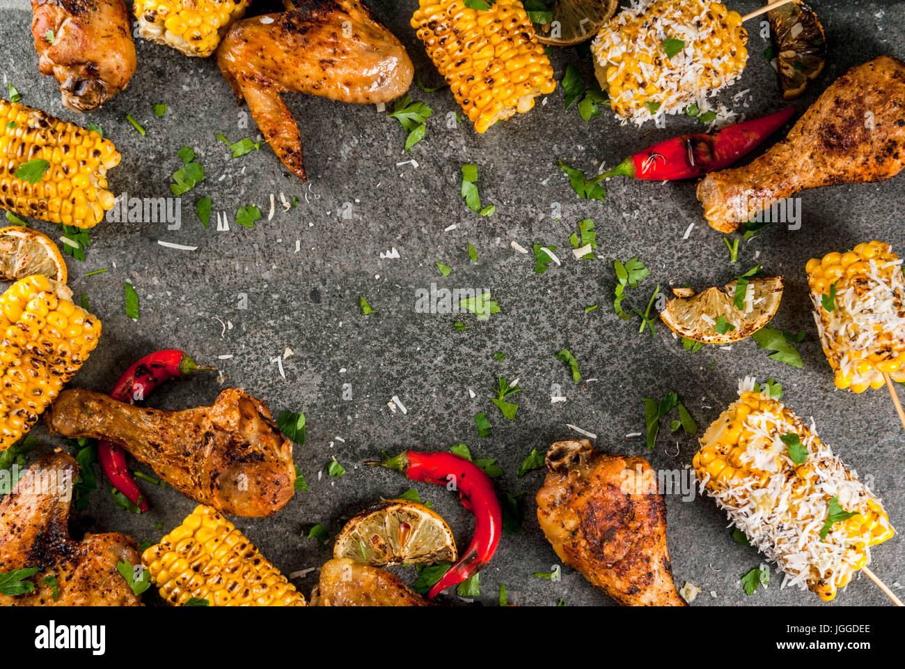 Sommer essen. Ideen für Grill, Grill-Party. Mais und Hühnchen (Beine, Flügel) gegrillt, gebraten in Brand. Mit einer Prise Käse (Elotes) hot Chili pep Stockfoto