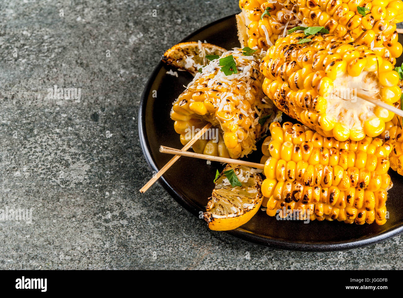 Sommer essen. Ideen für Grill und Grill-Partys. Gegrilltem Mais auf Feuer gegrillt. Mit einer Prise Käse (mexikanische Elotes), scharfe Paprika, Zitrone. Stockfoto