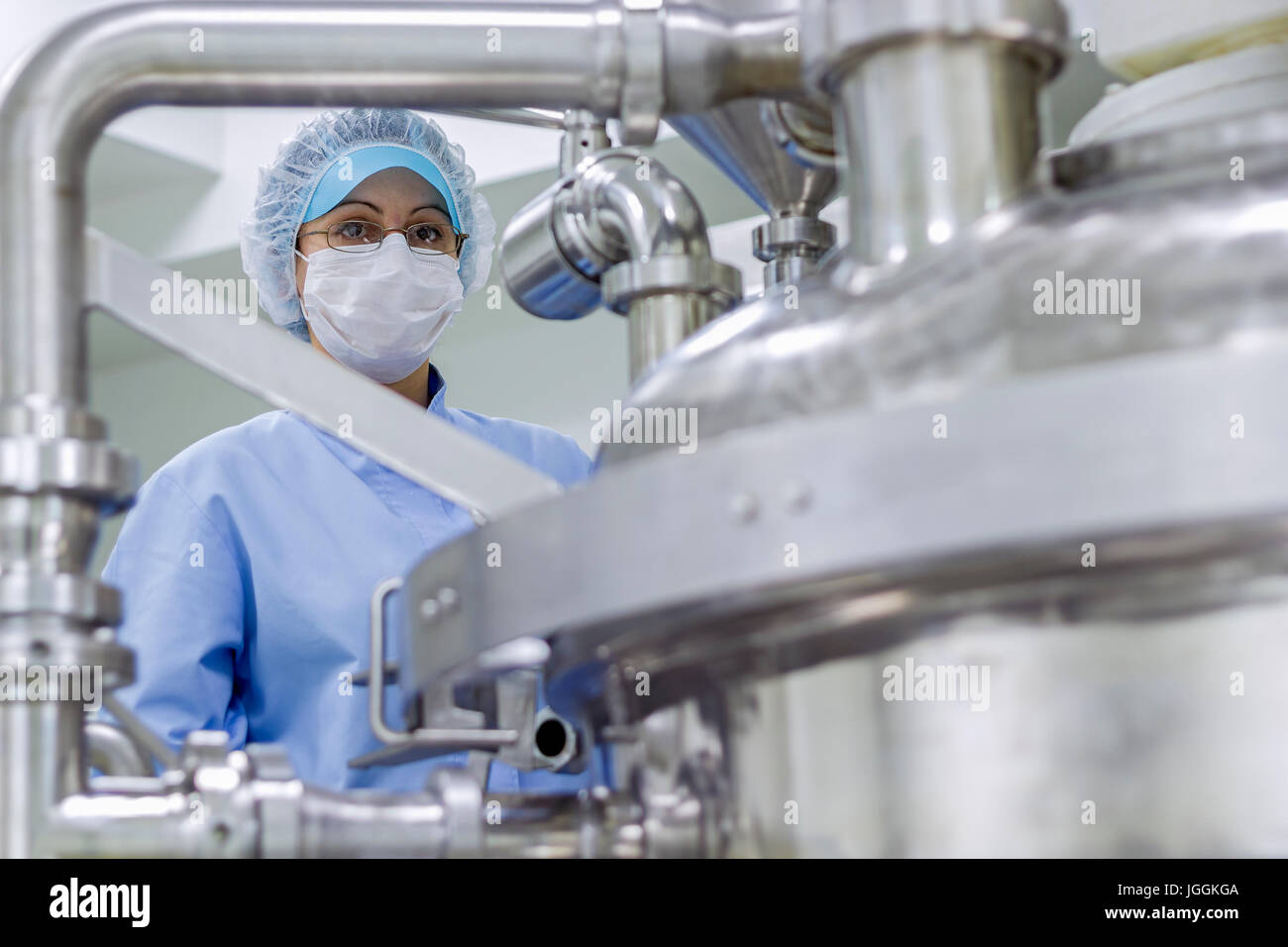 Vorbereitung der Maschine für Arbeiten in Pharmafabrik. Arbeitnehmerin Schutzkleidung in pharmazeutischen Anlage. Stockfoto