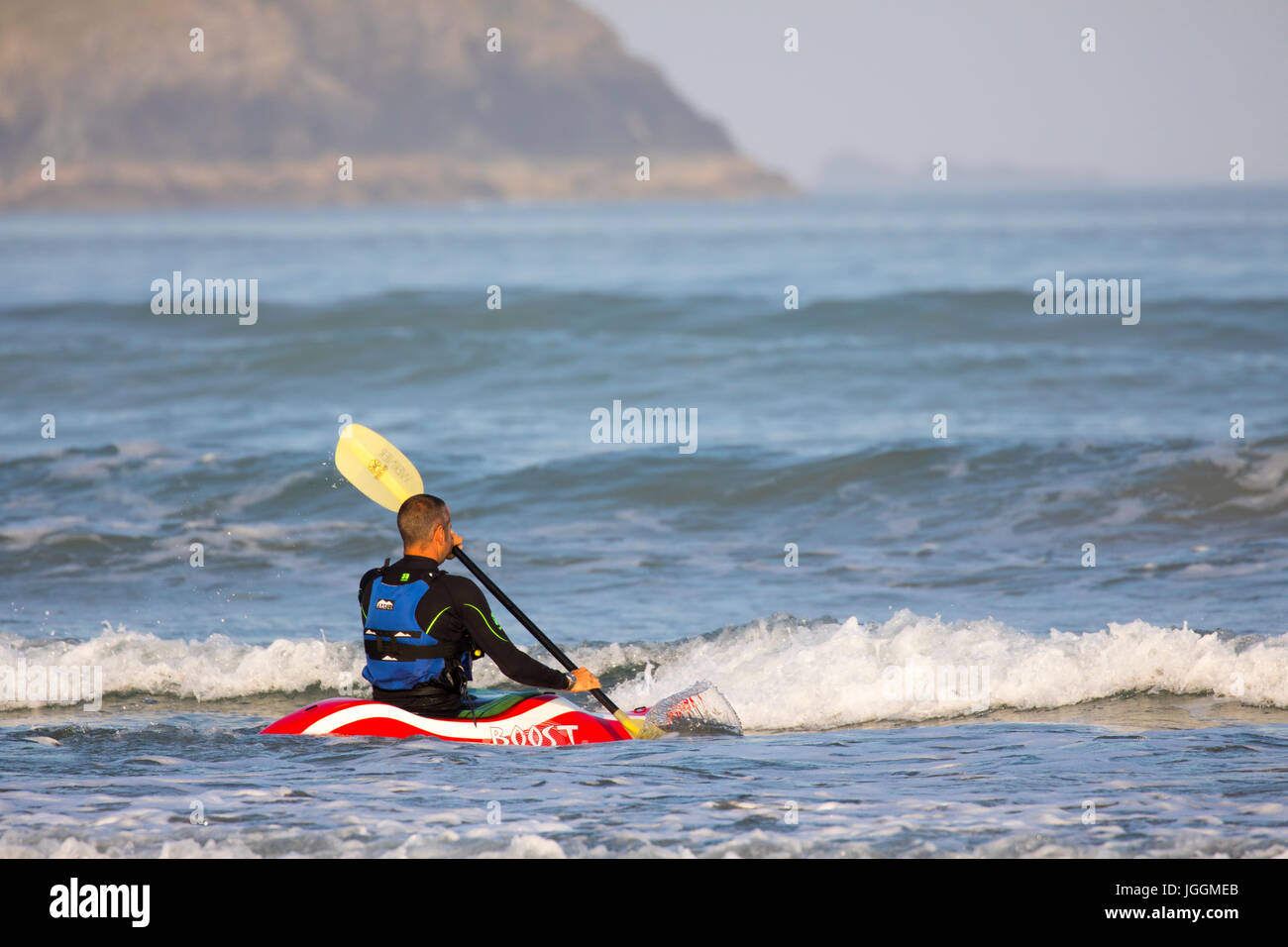 Ein Meer Kanuten oder Kajakfahrer paddeln durch die Wellen an den beliebten Surf Strand Polzeath auf der Suche nach einer Welle zu fahren mit dem Kanu, Cornwall, UK Stockfoto Ein Meer Kanuten oder Kajakfahrer paddeln durch die Wellen an den beliebten Surf Strand Polzeath auf der Suche nach einer Welle zu fahren mit dem Kanu, Cornwall, UK Stockfoto