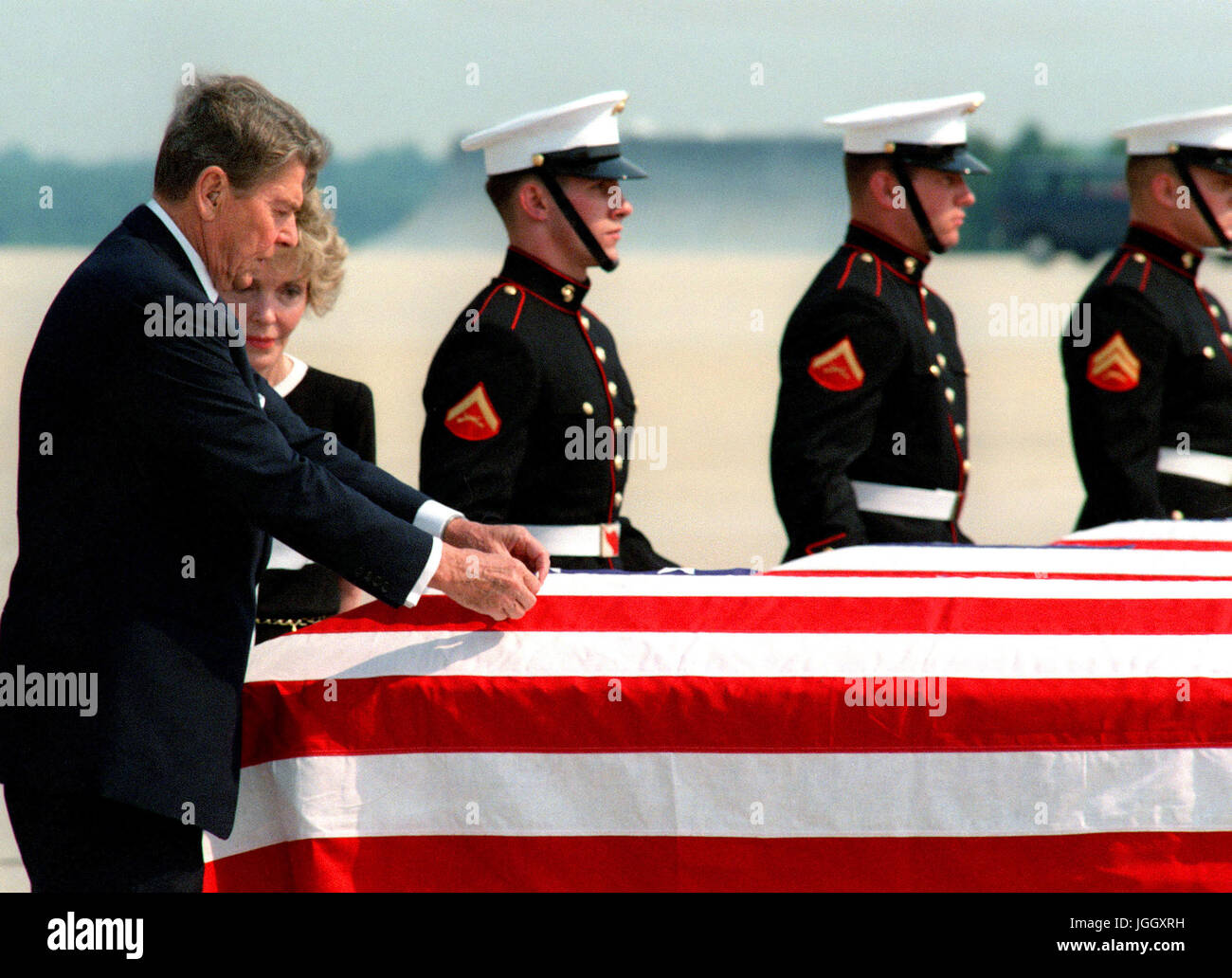Präsident Ronald Reagan legt eine Medaille auf eine Fahne drapiert Sarg von einer der vier Marines getötet in El Salvador. Stockfoto