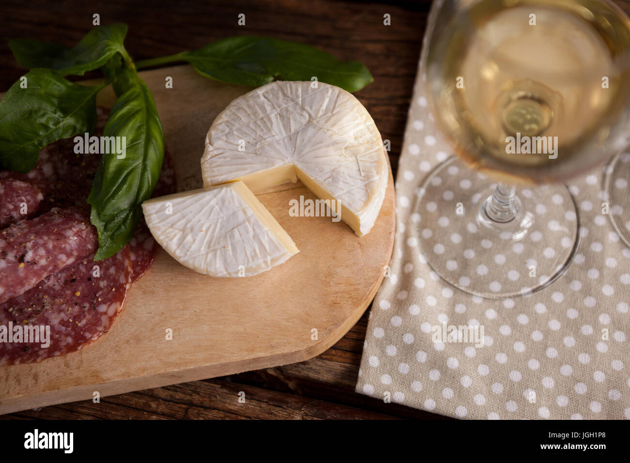 Nahaufnahme von Käse mit Fleisch und Weinglas auf Tisch Stockfoto