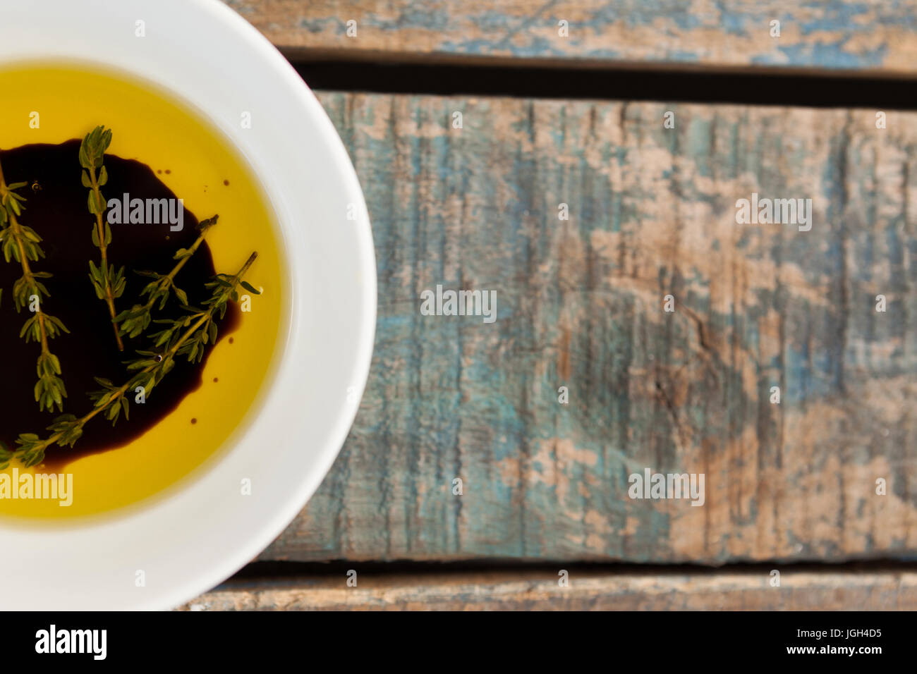 Bild von Kräutern in Olivenöl auf Holztisch beschnitten Stockfoto