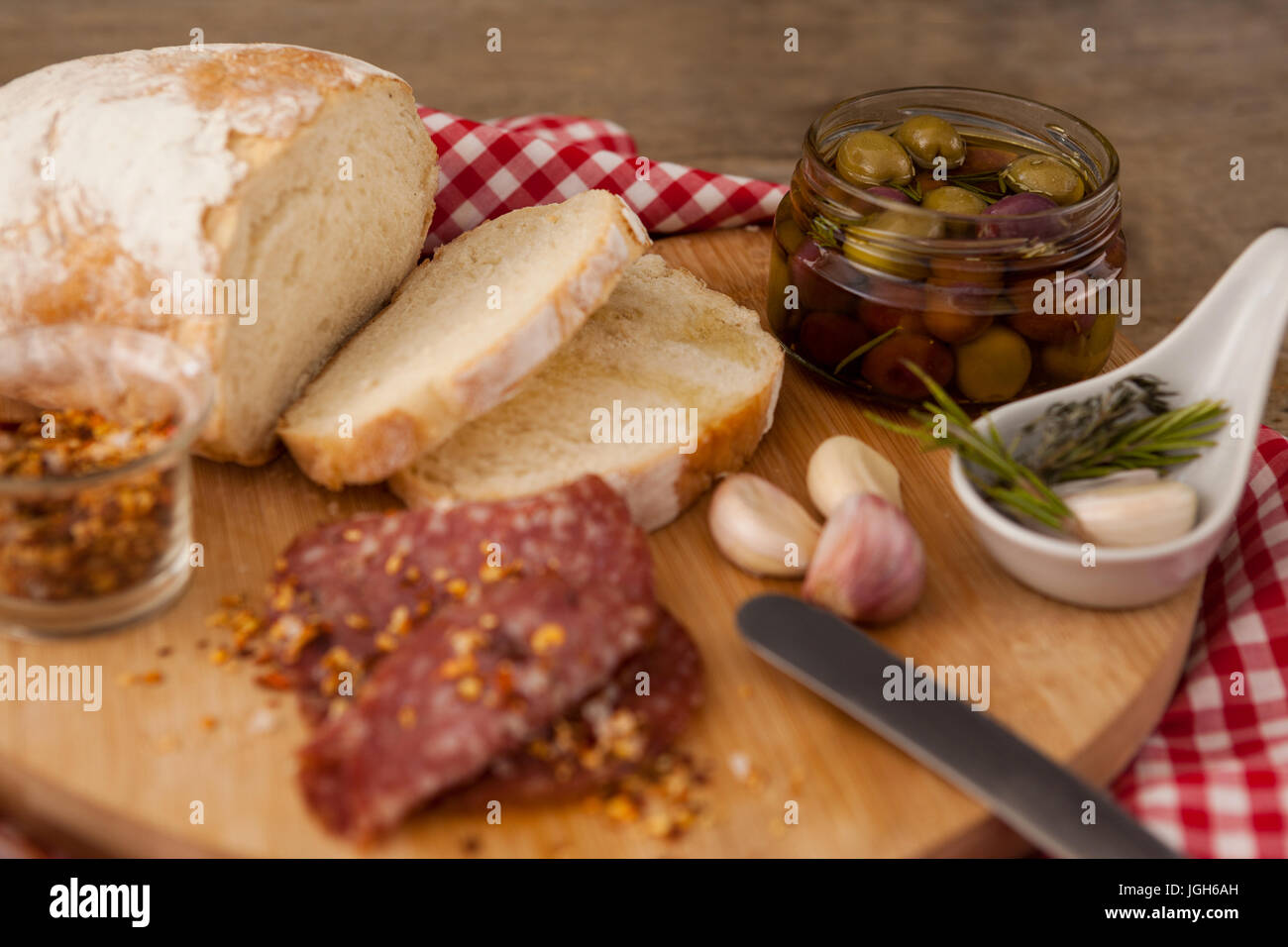 Nahaufnahme von Fleisch und Brot mit Oliven im Container auf Schneidebrett Stockfoto
