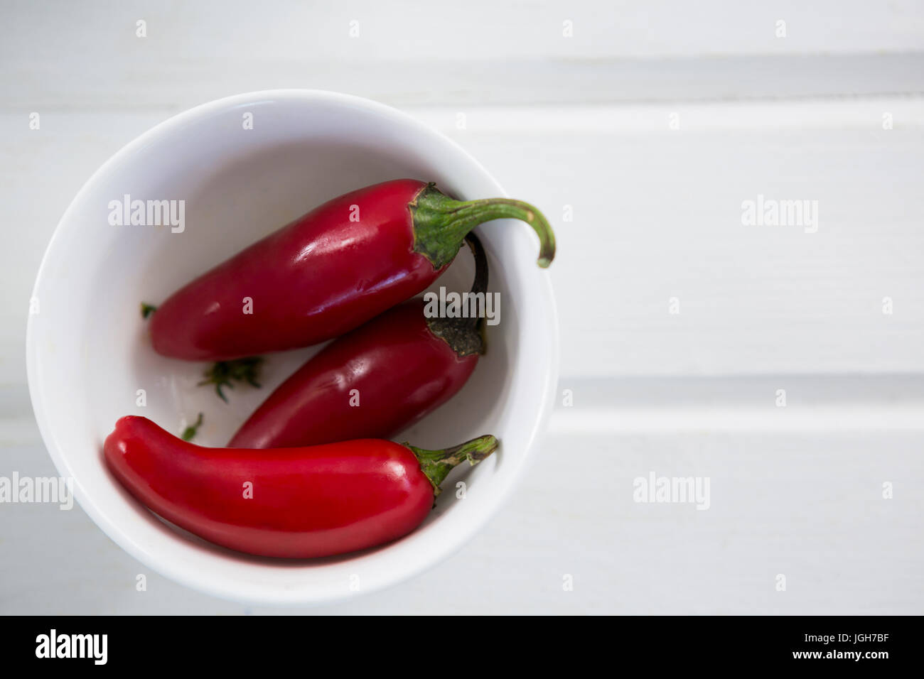 Eingelegte Paprika in Schüssel auf Holztisch Stockfoto