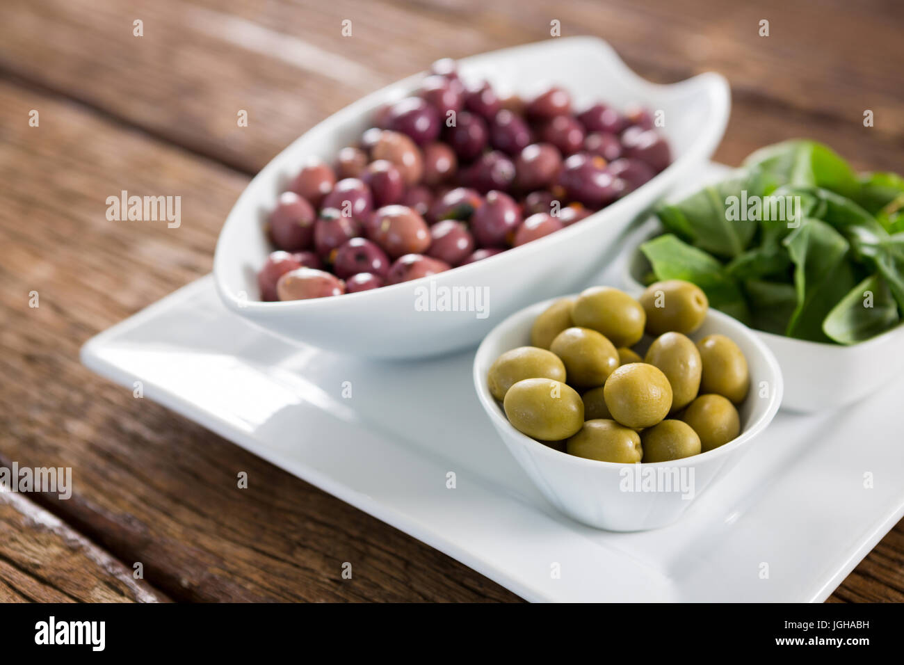 Marinierte Oliven mit Kräutern in Schüssel in Nahaufnahme Stockfoto