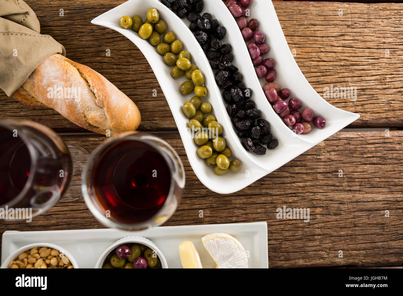 Marinierte Oliven mit Gläser Wein am Tisch in Nahaufnahme Stockfoto