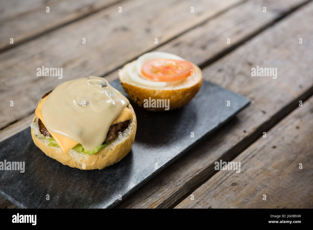 Erhöhte Ansicht-Sauce mit Käse und Fleisch auf Brötchen Stockfoto