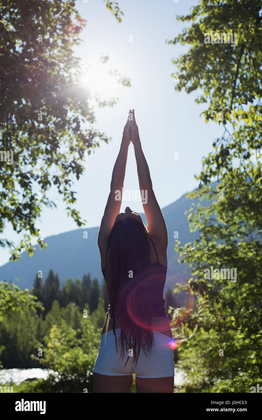 Rückansicht des Frau Yoga in einem grünen Wald an einem sonnigen Tag machen Stockfoto