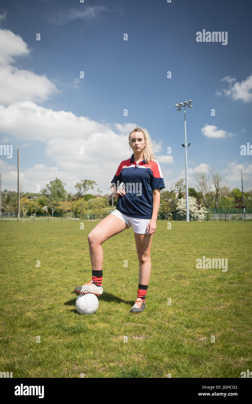 Volle Länge des weiblichen Fußballspieler mit Ball stehend auf auffangene gegen Himmel Stockfoto