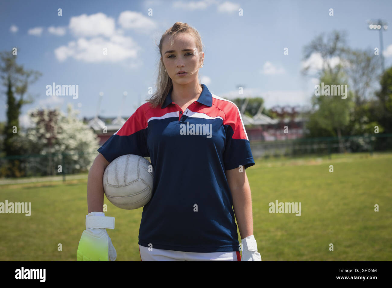 Porträt der jungen weiblichen Torwart Fußball Kugel steht auf Feld Stockfoto