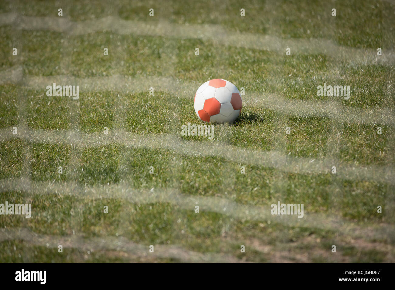 Fußball auf Spielfeld durch Net gesehen Stockfoto