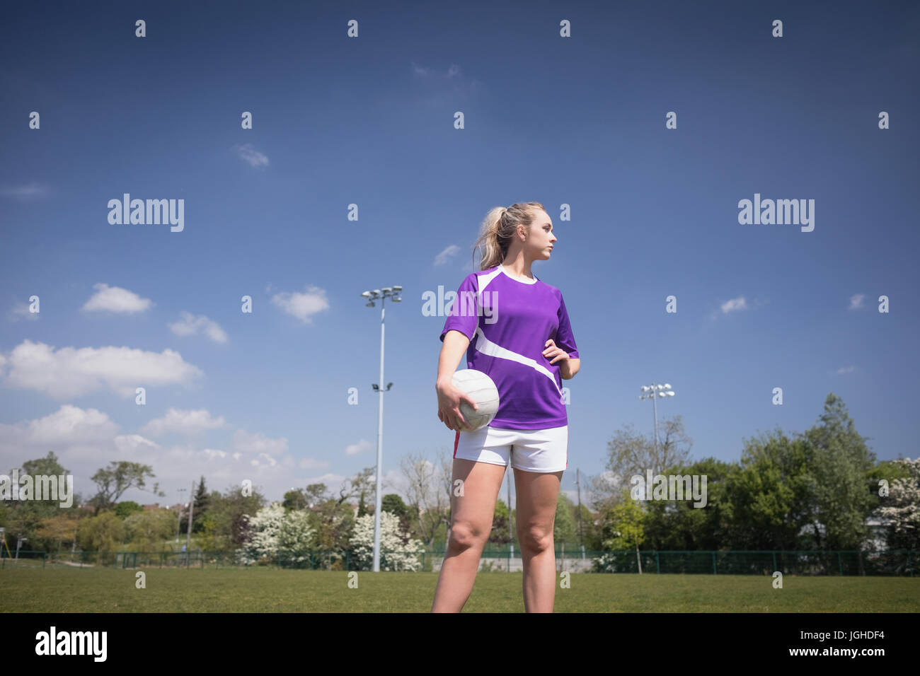 Weibliche Fußball-Spieler mit Ball wegsehen auf Feld Stockfoto