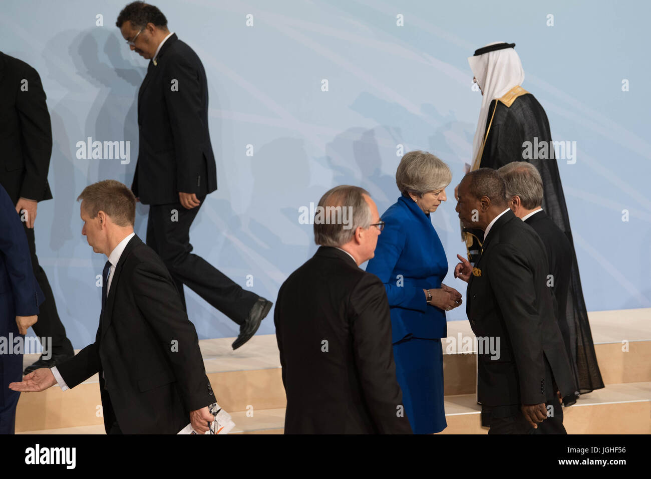 Premierminister Theresa May spricht mit UN-Generalsekretär Antonio Guterres (teilweise verdeckt) als Weltmarktführer für ein Familienfoto während des G20-Gipfels in Hamburg zu sammeln. Stockfoto