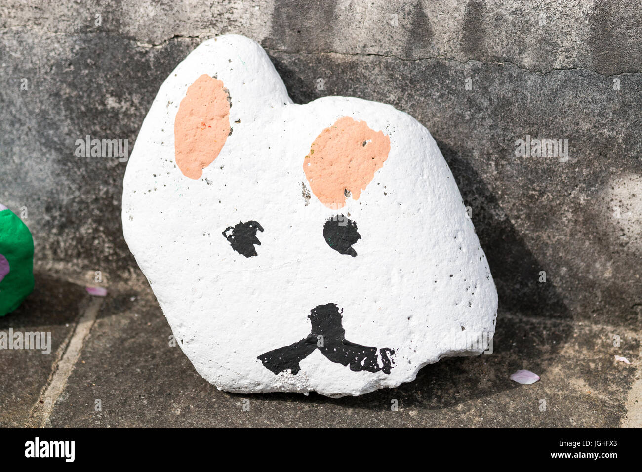 Japan, Tatsuno. Stein hielten gegen Wand der Schule mit cat face von Schule Kind gemalt. Stockfoto