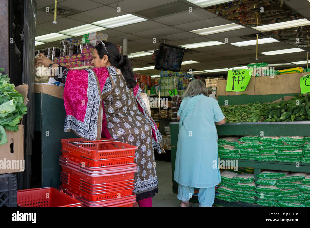 Zwei asiatischen Frauen in ethnische Mode shopping für Gemüse in einem Supermarkt an der 37th Avenue in Jackson Heights, Queens, New York City. Stockfoto