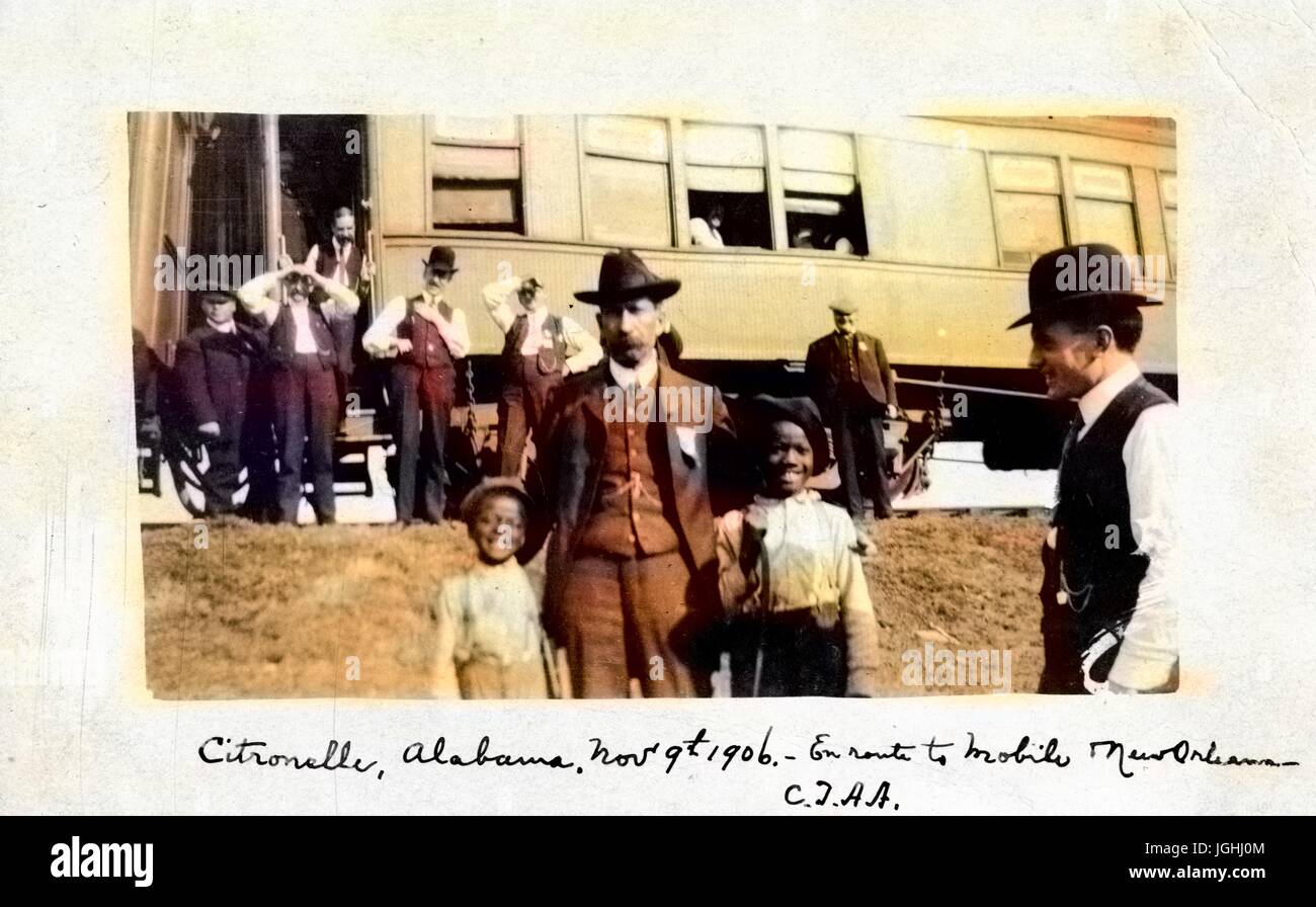 Zwei junge Afro-amerikanische Kinder posieren mit einem Eisenbahn-Leiter bei einem Stopp in Citronelle, Alabama, ein Waggon im Hintergrund, 9. November 1906. Hinweis: Bild wurde digital eingefärbt wurde mit einem modernen Verfahren. Farben können Zeit ungenau sein. Stockfoto