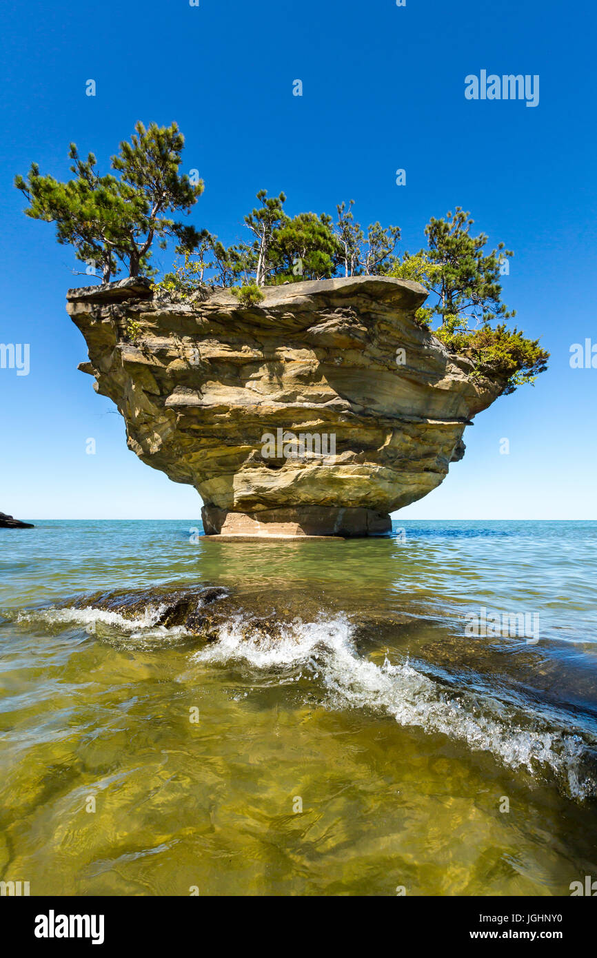 Eine Lake Huron-Welle schwappt über einen Felsen am Rübe Rock in der Nähe von Port Austin Michigan. Klare Gewässern ermöglichen einen Blick unter Wasser Stockfoto