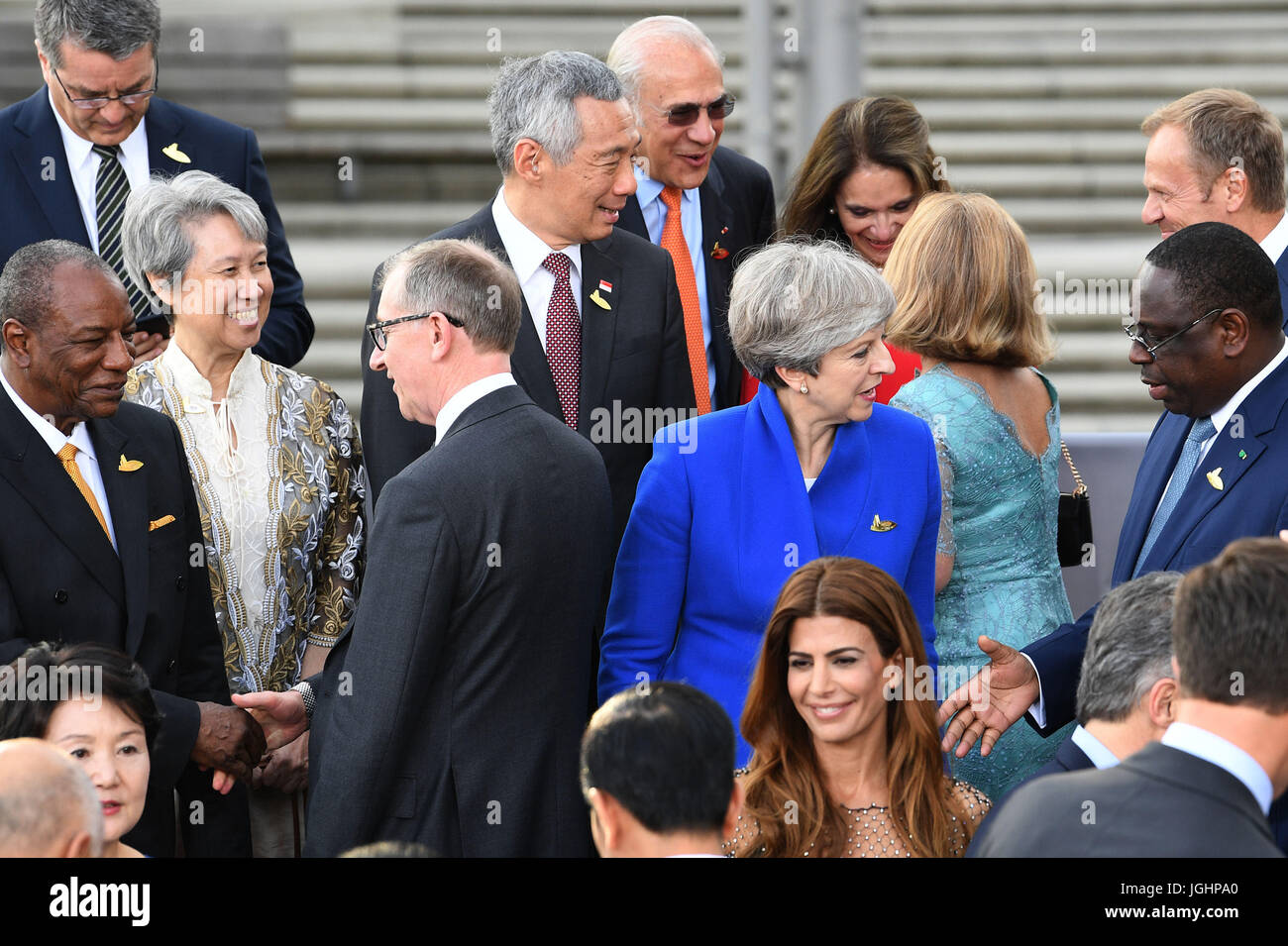 Premierminister Theresa May spricht senegalesische Präsident Macky Sall (rechts) und ihr Ehemann Philip Guinean Präsident Alpha CondŽ (links), während ein Gruppenfoto als G20-Führer spricht und deren Ehegatten kommen, um ein Konzert in der Konzerthalle der Elbphilharmonie in Hamburg zu besuchen. Stockfoto